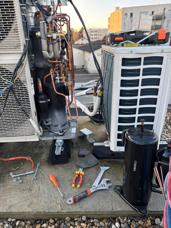 Technicien ASLANE en intervention de dépannage sur un groupe extérieur de pompe à chaleur en toiture